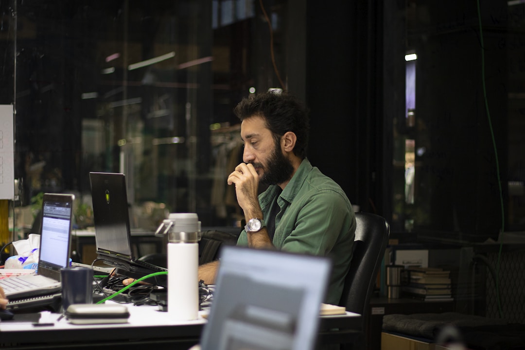 A man sitting at a desk with a laptop, focused on RFP distribution and vendor communication strategies.